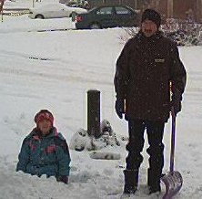 Steve shoveling and Madelaine playing in the snow with a shovel